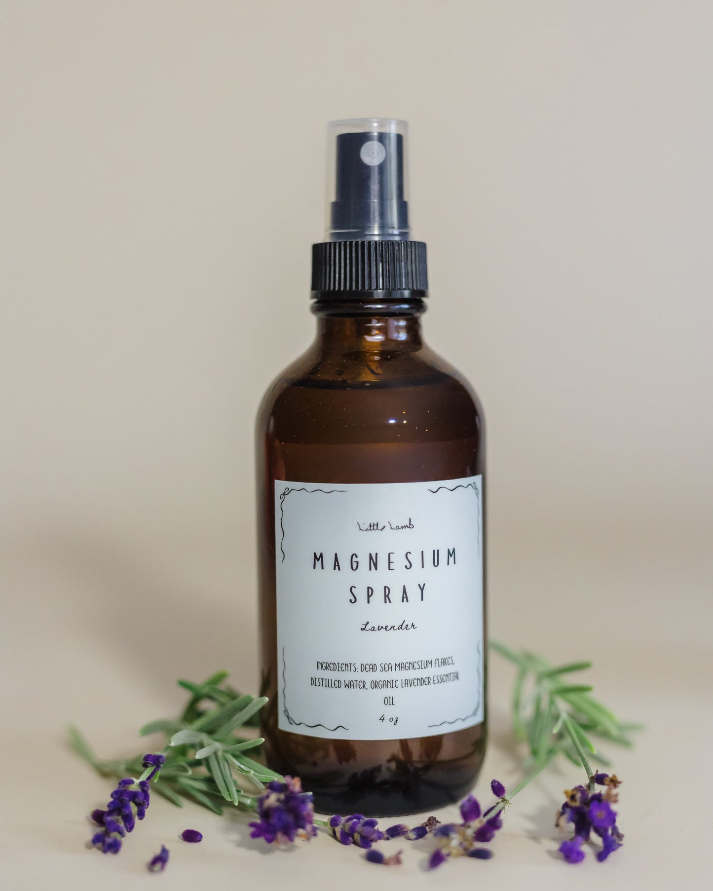 Brown spray bottle labeled 'Magnesium Spray' with lavender flowers on a neutral background