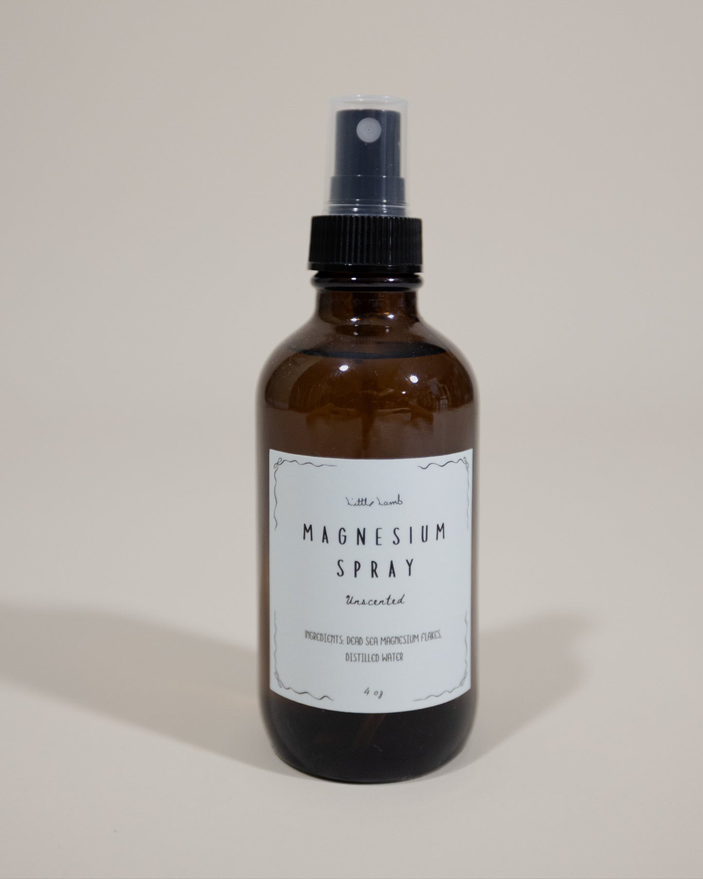 Brown spray bottle labeled 'Magnesium Spray' on a beige background